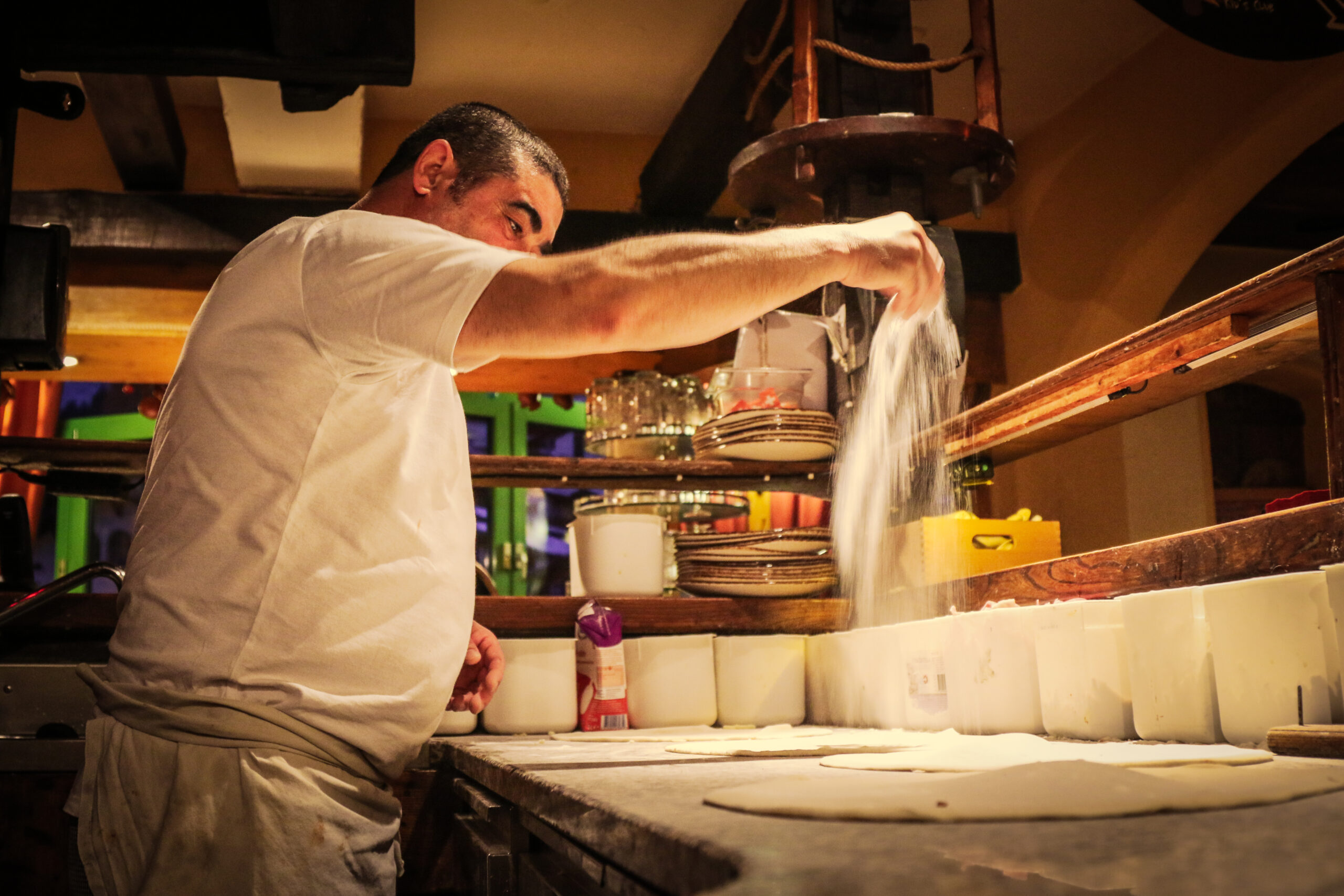 Pizzaiolo bei der Zubereitung einer Pizza