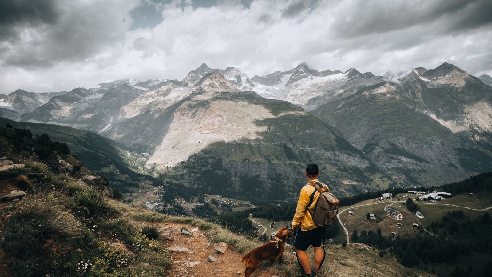 Hiker with dog overlooking the mountains in Zermatt, Switzerland